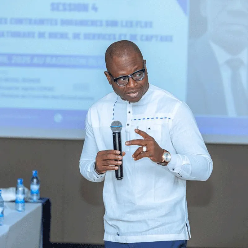 Aimé Djikoloum Guessimbaye prenant la parole, micro en main, lors d’une conférence